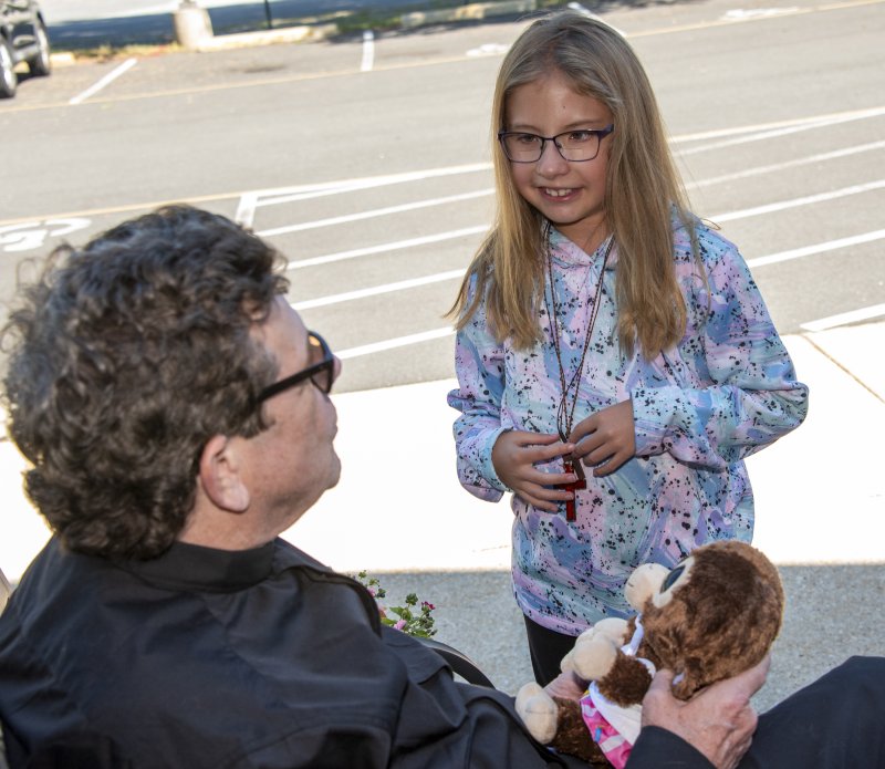 Shea Brennan listens as her friend's pet monkey is blessed by Pastor Tad Thayer.